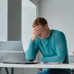 Propietario de vivienda vacacional en Gran Canaria estresado revisando reseñas en su portátil.