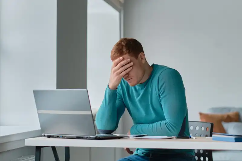 Propietario de vivienda vacacional en Gran Canaria estresado revisando reseñas en su portátil.