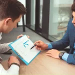Agente inmobiliario analiza datos de mercado con un propietario ante las señales de desaceleración en la venta de viviendas